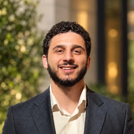 Firas Bdaiwi, smiling, in a dark suit